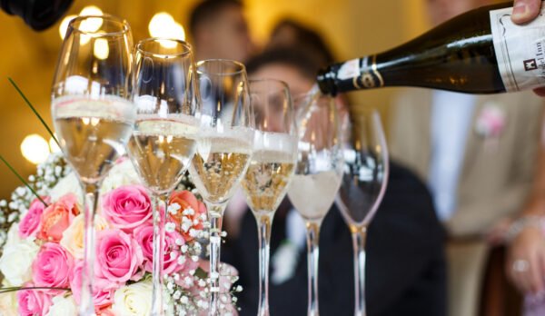 man-pours-champagne-glasses